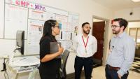 Clinicians huddle for a discussion in a clinic hallway